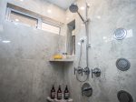 The large walk-in shower has body sprays and a ceiling rain head for a spa-like experience while getting yourself clean.